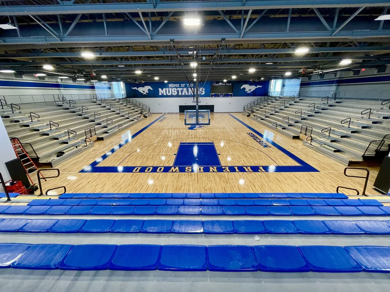 Blue bleachers overlook the completed basketball court.