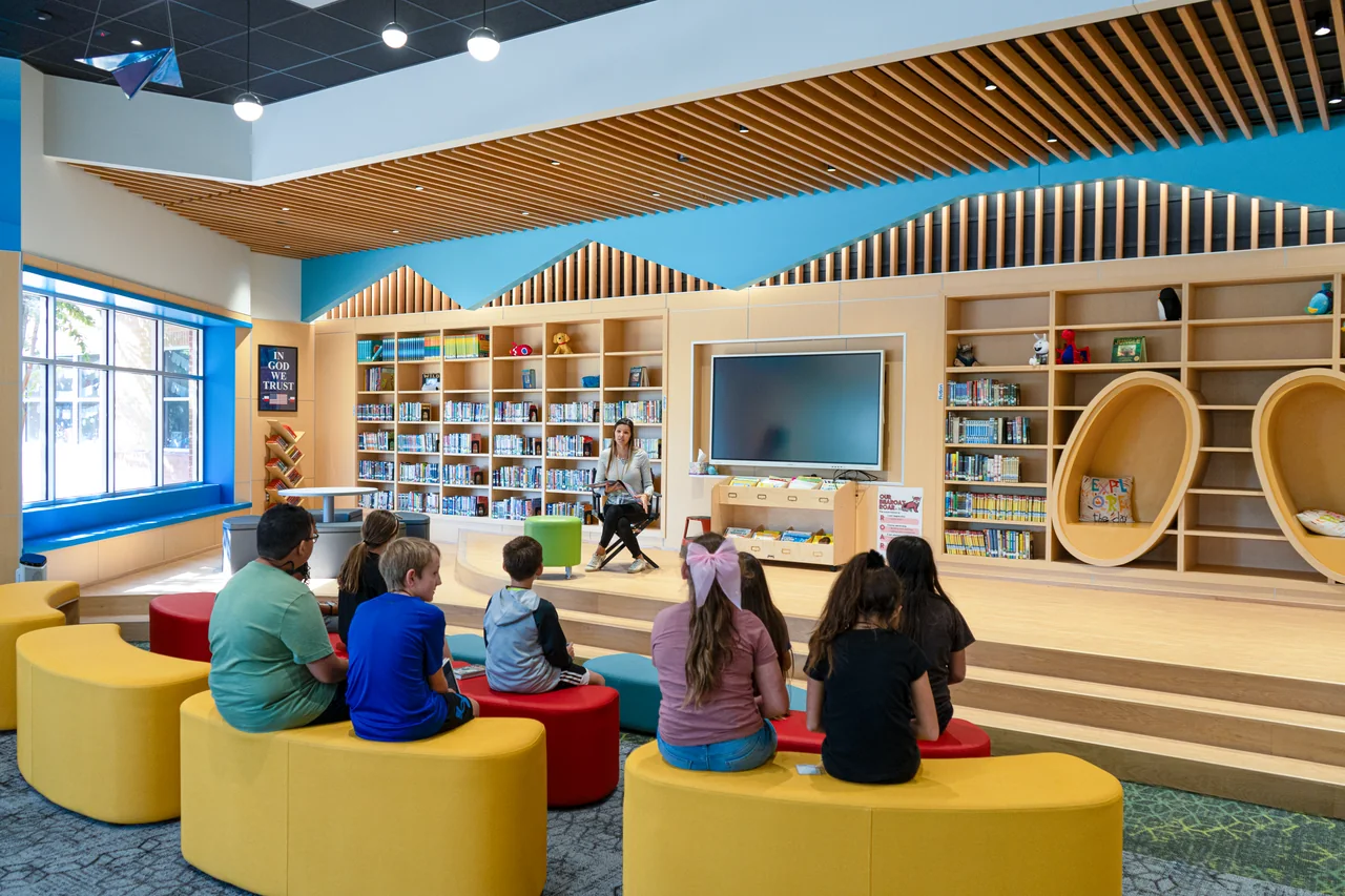Students gathered around a small presentation platform in the library.